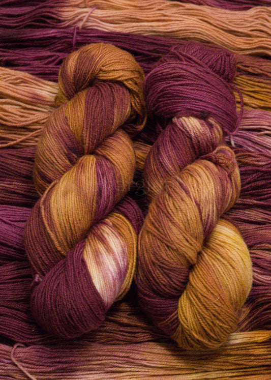 Close-up of skeins of multicolored yarn with shades of burgundy and orange.