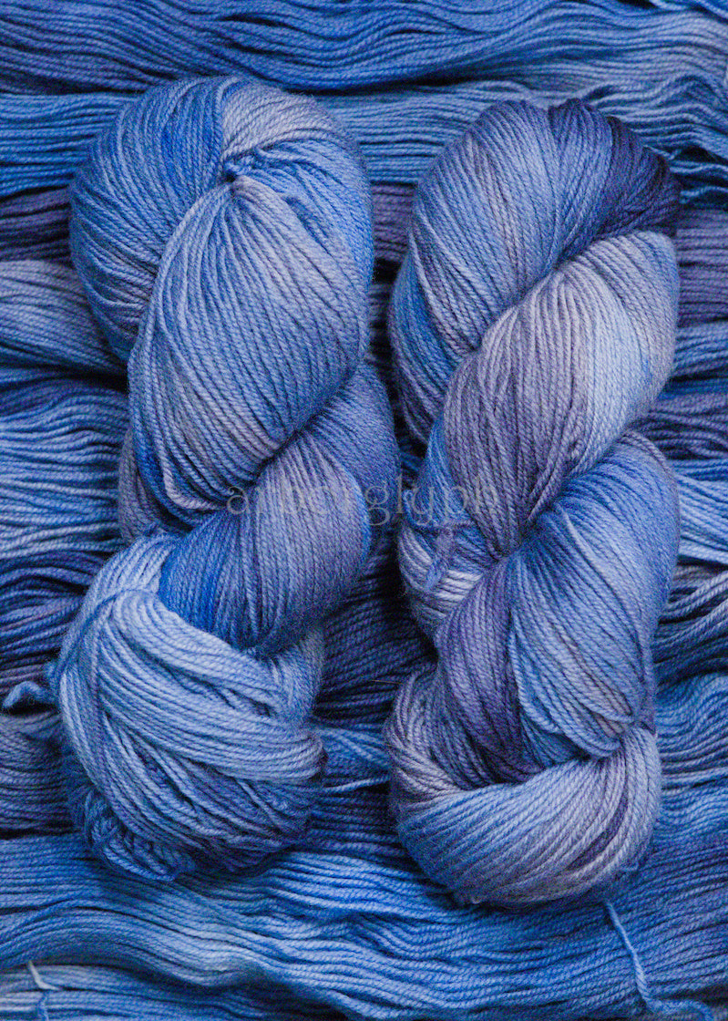 Close-up of blue yarn skeins with a brand name in the corner.