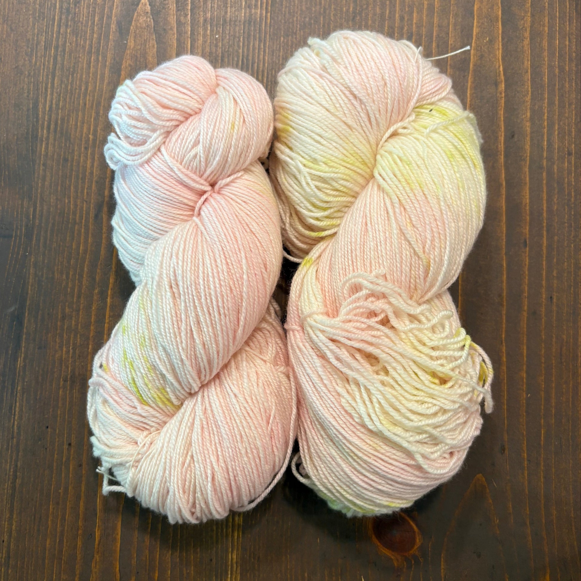 skeins of hand dyed Merino/silk blend yarn in pink and chartreuse. 