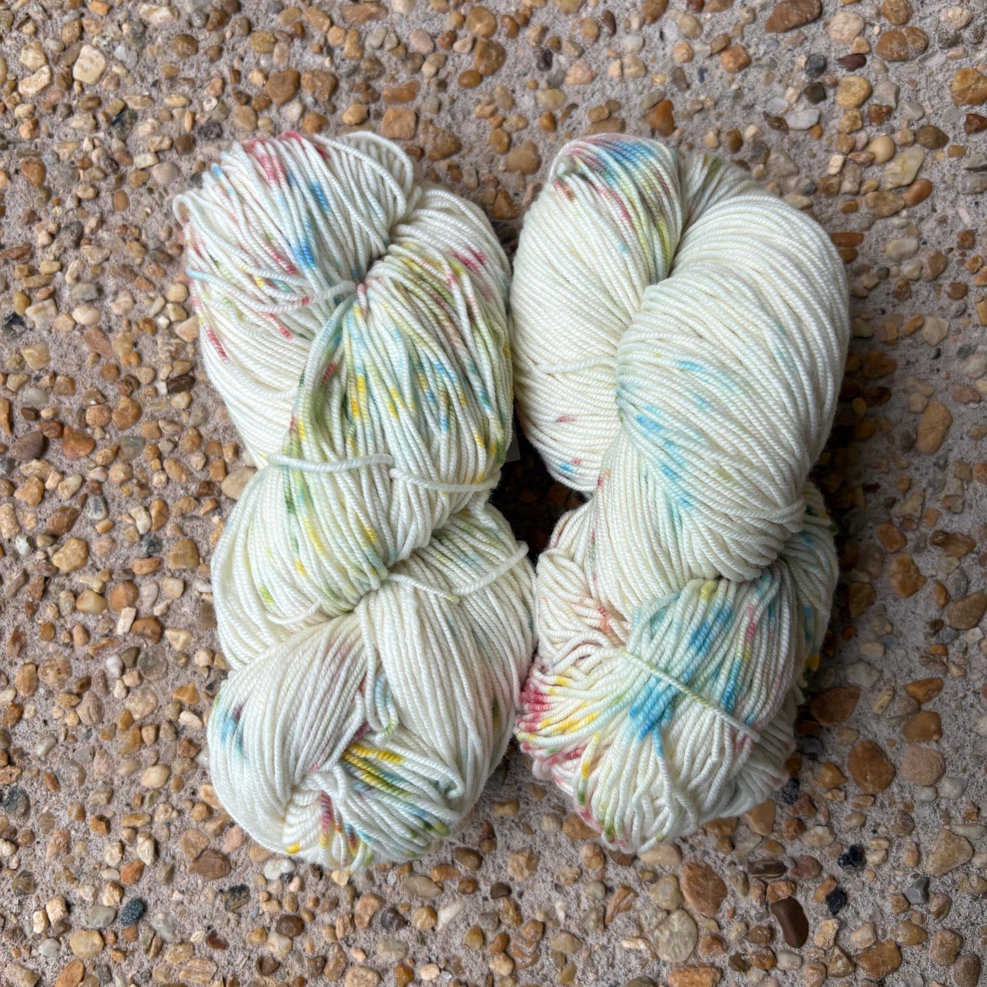 Skein of hand-dyed Confetti yarn in white Merino with pastel rainbow speckles