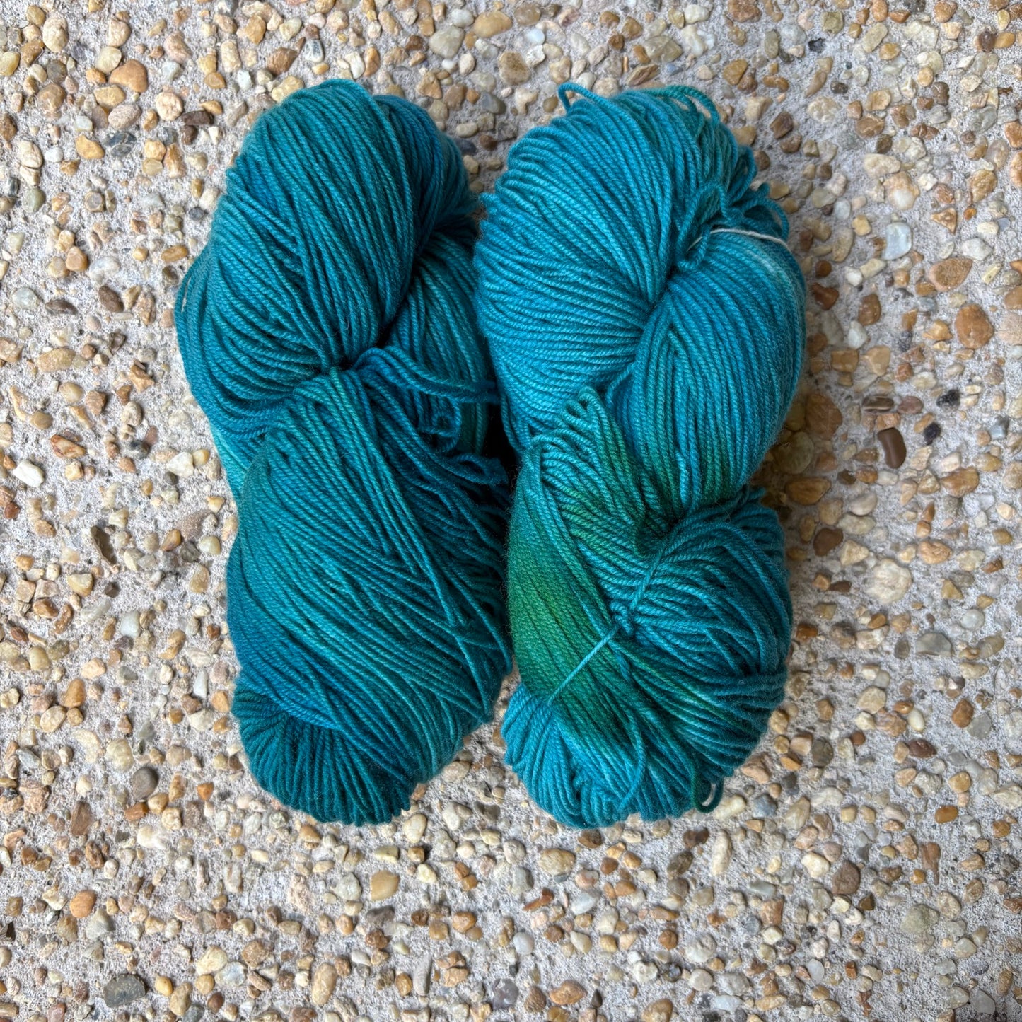 Skein of hand-dyed Lagoon yarn in deep tonal teal Merino, blue melting into sea-green